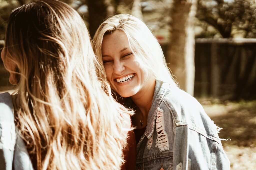 A young professional woman laughing openly and smiling confidently during a meeting, illustrating the self-esteem benefits of orthodontic treatment.