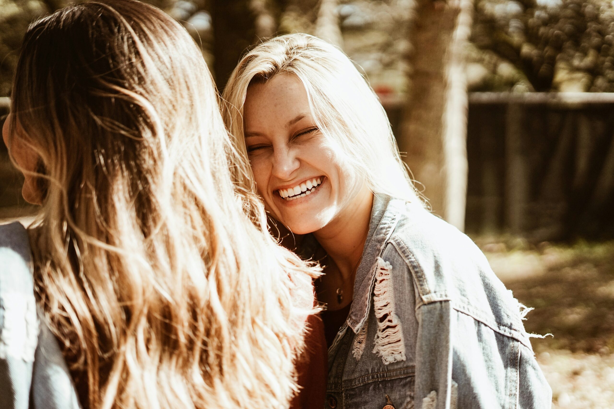 A young professional woman laughing openly and smiling confidently during a meeting, illustrating the self-esteem benefits of orthodontic treatment.