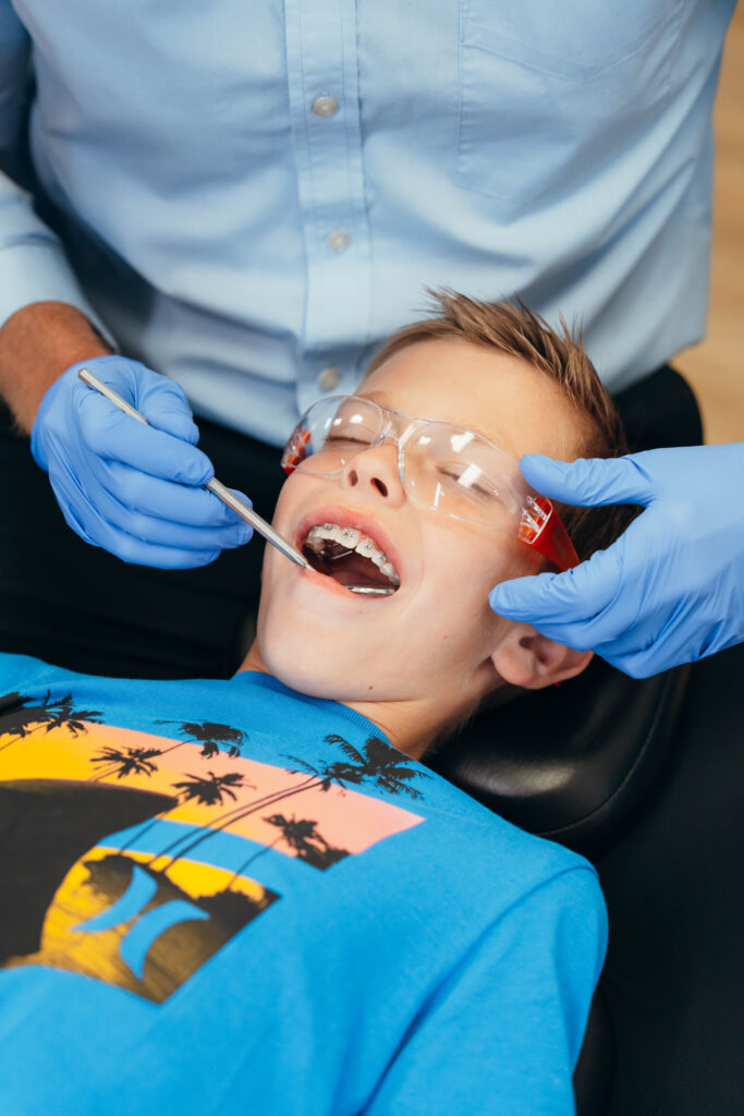 Boy getting his braces looked at by an orthodontist