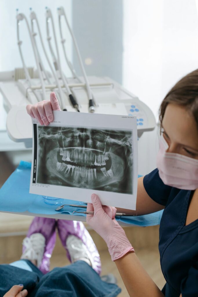 Orthodontist reviewing dental X-rays to determine if a patient needs braces treatment.