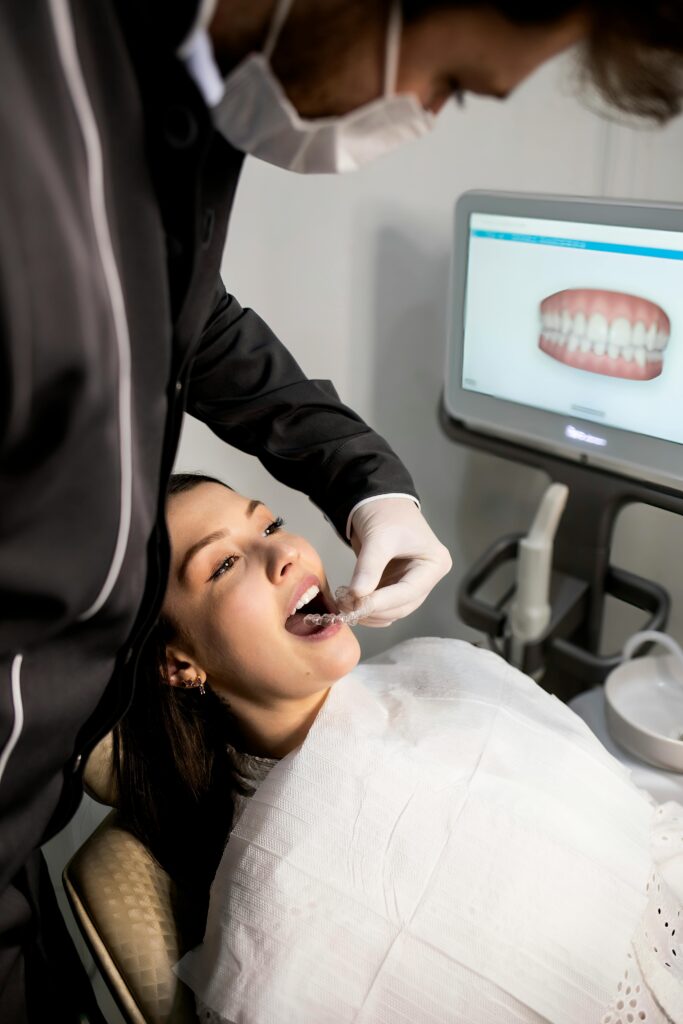 Person getting a consultation for Invisalign clear aligners on teeth, showing nearly invisible orthodontic treatment for straightening teeth