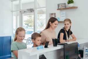 Kids and mother at the counter at Prince Orthodontics in American Fork, UT